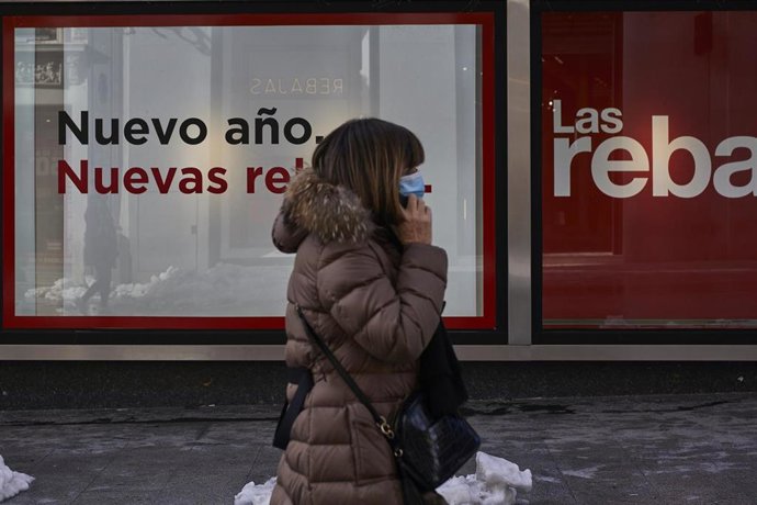 Archivo - Una persona pasa por delante de un establecimiento las rebajas de invierno