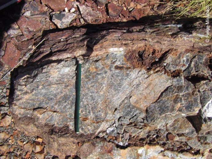 Barita de 3.500 millones de años (abajo) con una estera microbiana fosilizada (arriba). La barita es parte de la formación Dresser en el noroeste de Australia