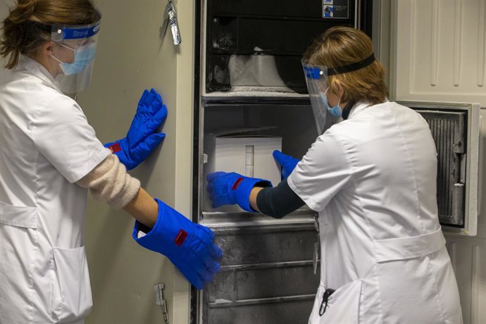 Archivo - 26 December 2020, Belgium, Leuven: Health workers store a box of the first doses of the Pfizer-BioNTech coronavirus vaccine in a freezer at the UZ Leuven hospital. Photo: Nicolas Maeterlinck/BELGA/dpa