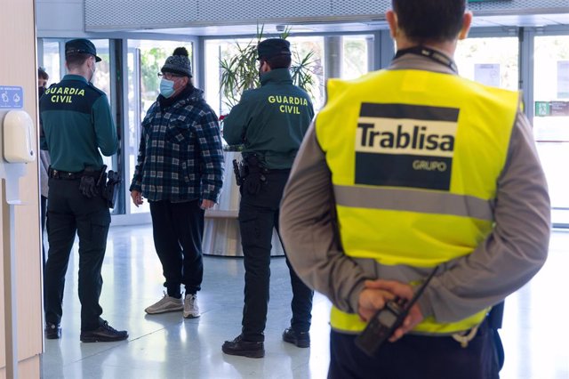 Agentes de la Guardia Civil y empleados de seguridad vigilan a los pasajeros en el interior del Aeropuerto de Ibiza  