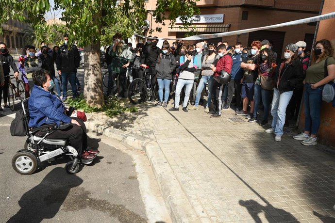 Una mujer, familiar de uno de los detenidos, conversa con un grupo de personas que se ha concentrado en las inmediaciones de  la Comisaría de Policía de Ruzafa, en la calle Zapadores de Valencia, Comunidad Valenciana (España), a 19 de febrero de 2021.