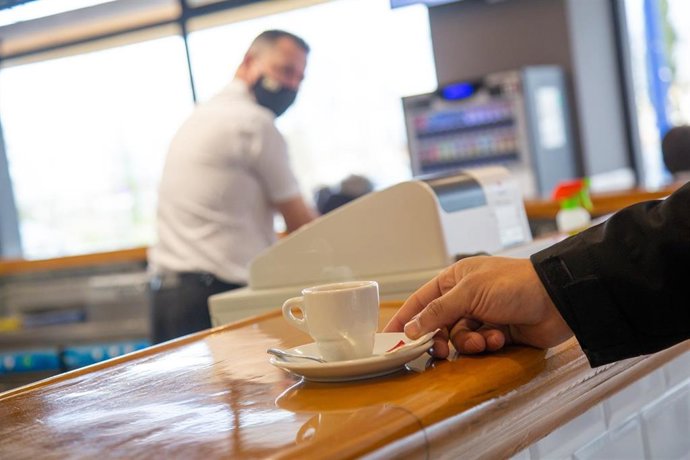 Un cliente recoge una taza de café en el pacense Bar Venero