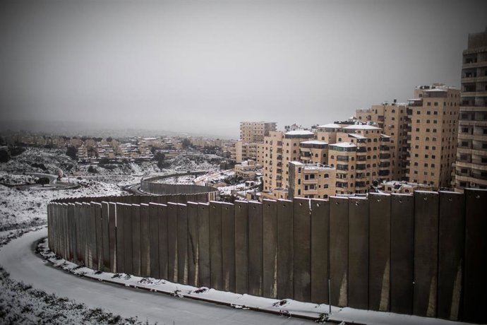 El muro de separación que divide Jerusalén cubierto por un inusual manto de nieve en una imagen tomada durante esta semana. 