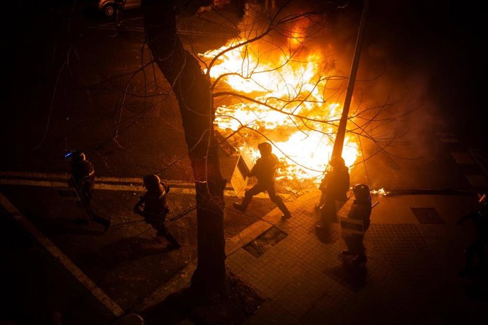 Manifestantes queman contenedores durante una manifestación contra el encarcelamiento del rapero y poeta Pablo Hasel en Barcelona (España), a 18 de febrero de 2021. El rapero Pablo Hasel ingresó la mañana del martes pasado en el centro penitenciario de 