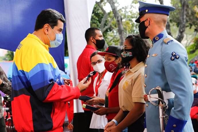 HANDOUT - 12 February 2021, Venezuela, Caracas: Nicolas Maduro (L), president of Venezuela, speaks with young people during an event to mark the Youth Day at the Miraflores presidential palace. Photo: Jhonander Gamarra/Prensa Miraflores/dpa - ACHTUNG: N