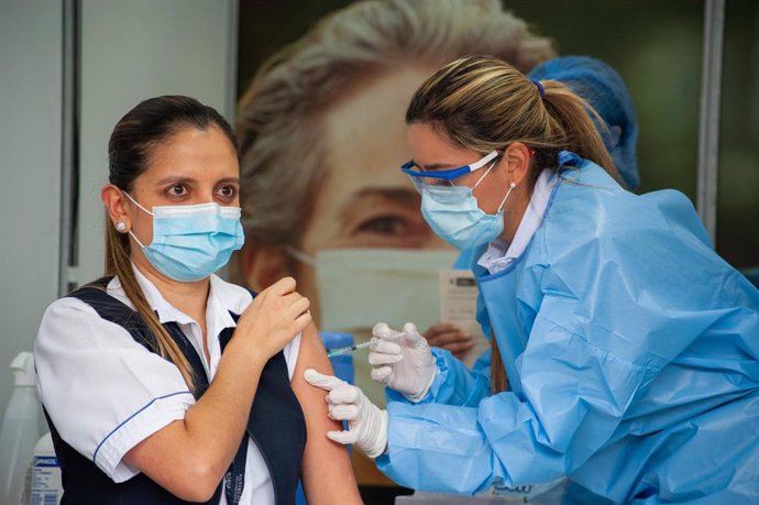 18 February 2021, Colombia, Bogota: A health worker receives a dose of Pfizer-BioNtech's Covid-19 vaccine at the start of the Coronavirus vaccination campaign in nine hospitals. Atotal of 12,582 doses of Pfizer-BioNtech's Covid-19 vaccine were distribu