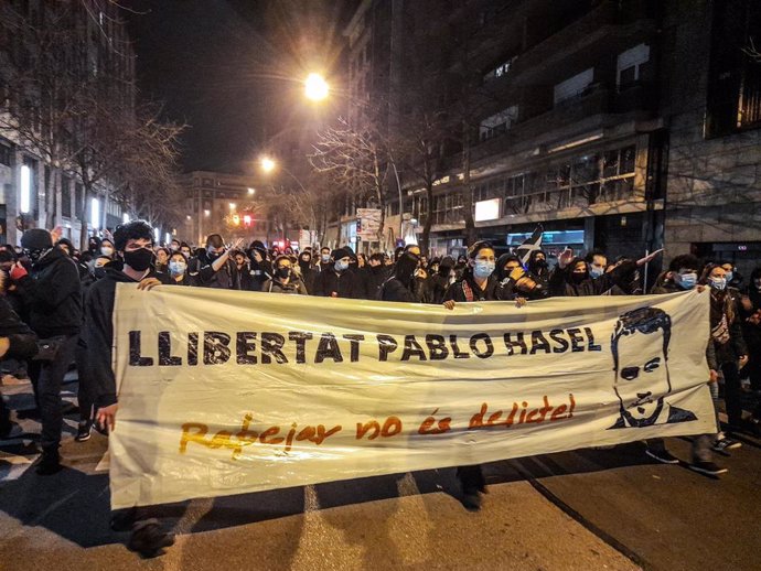 Varias personas sostienen una pancarta donde se lee "Llibertat Pablo Hasel. Rapear no es delito", durante la manifestación en Girona