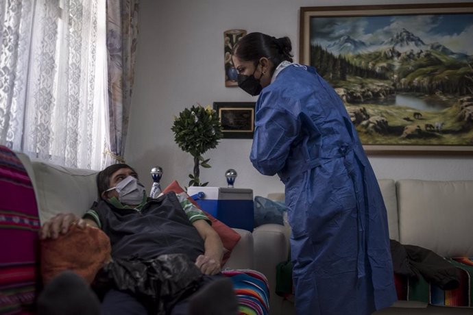 18 February 2021, Mexico, Mexico City: Nurse Elena Tello vaccinates an elderly man with a dose of AstraZeneca coronavirus vaccine. City medical workers come to an elderly residence to administer people who do not have the opportunity to visit vaccinatio