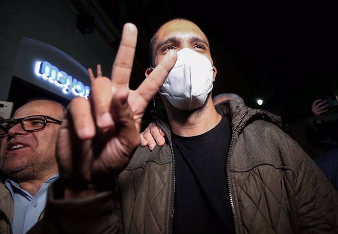 19 February 2021, Algeria, Algiers: Algerian journalist Khaled Drareni flashes the victory sign as he arrives at his home, following his release from the Kolea prison. Algeria released more than 30 activists from jail under presidential pardons issued a