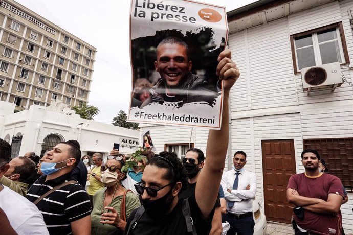 Archivo - 21 September 2020, Algeria, Algiers: A man holds up a poster bearing the picture of Algerian journalist Khaled Drareni during a solidarity rally at the Tahar Djaout Press House. Drareni, who has been under arrest since 29 March 2020, received 
