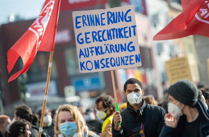 20 February 2021, Berlin: A participant holds a placard reading "Remembrance - Justice - Clarification - Consequences" during a demonstration to commemorate the victims of the right-wing extremist attack in Hanau on 19 February 2020. Photo: Christophe G