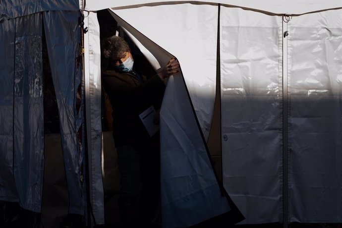 10 February 2021, United Kingdom, London: A man emerges after getting a Covid-19 test at a mobile testing unit at the Waylett Place car park, London after a case of the South African variant was discovered in the area. Photo: Aaron Chown/PA Wire/dpa
