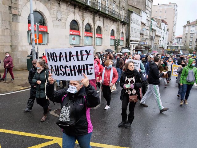 Varias personas participan en una manifestación contra la conocida como ‘Ley Auschwitz’, en Santiago de Compostela, Galicia (España), a 20 de febrero de 2021. Esta acción, convocada por Policías por la Libertad, protesta contra propuesta de reforma de la 