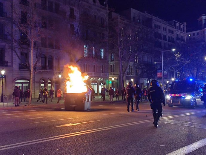 Cremen un contenidor en el passeig de Grcia de Barcelona durant la manifestació en suport a Pablo Hasel