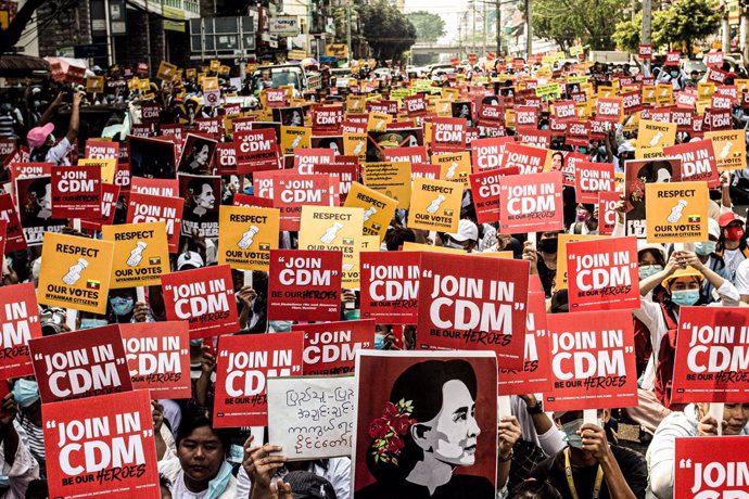Manifestantes contra el golpe de Estado en Rangún con pancartas de apoyo al movimiento de desobediencia civil, CDM por sus siglas en inglés