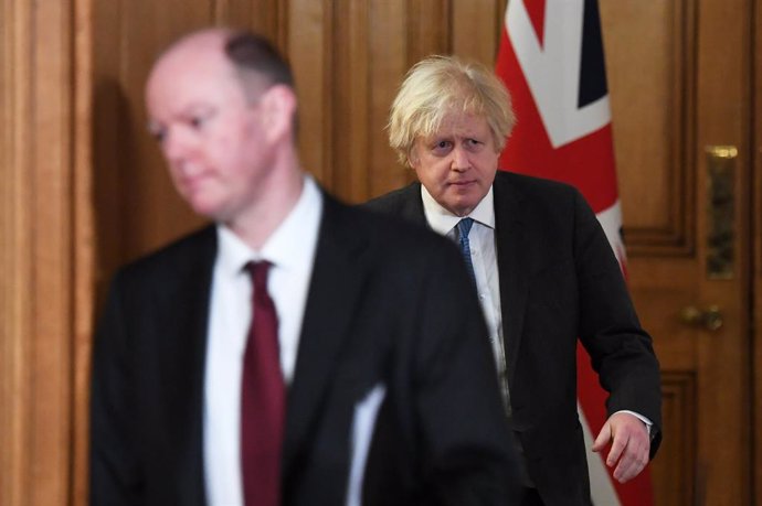 15 February 2021, United Kingdom, London: UK Prime Minister Boris Johnson (R)and Chief Medical Officer Chris Whitty arrive for during a media briefing on coronavirus (COVID-19). Photo: Stefan Rousseau/PA Wire/dpa