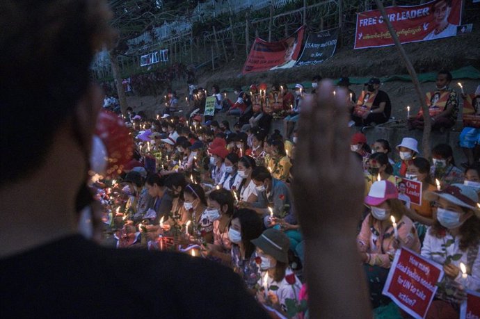 21 February 2021, Myanmar, Yangon: A man give three-finger salute during the candle-light vigil protest against the military coup near Embassy of the United States of America in Yangon. Photo: Thet Htoo/ZUMA Wire/dpa