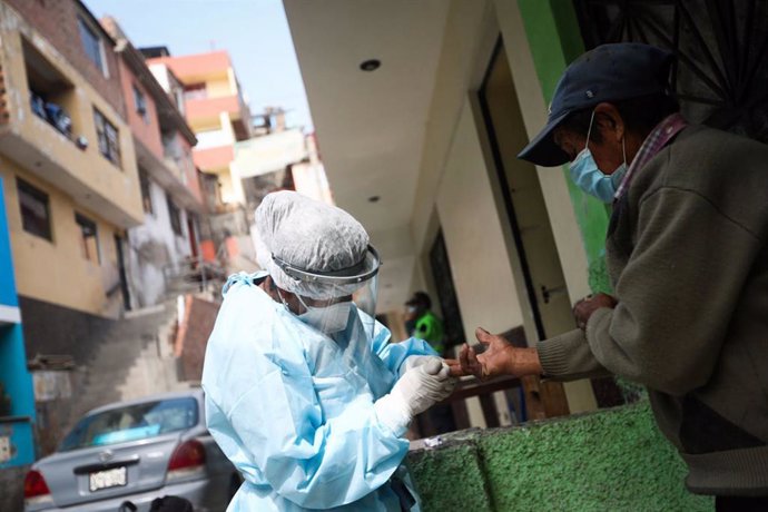 Archivo - 20 August 2020, Peru, Santa Anita: A health worker takes a blood sample from a man for the coronavirus test during a door-to-door testing campaign. Photo: Jhonel Rodríguez Robles/Agentur Andina/dpa
