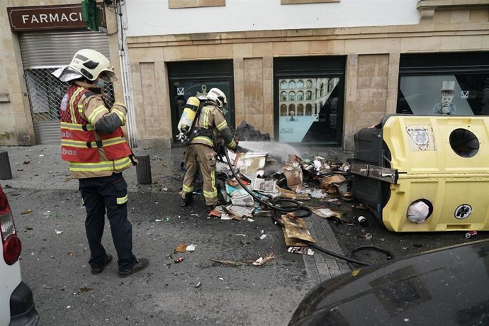 Los bomberos apagan el fuego de un contenedor durante los altercados producidos en una manifestación contra el encarcelamiento de Pablo Hasel 