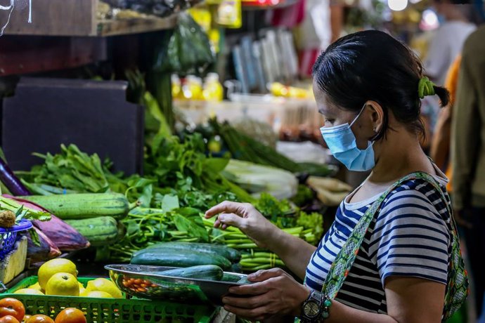 Una mujer en un puesto de verduras en un mercado de Manila, Filipinas.