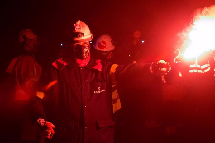 Archivo - Un trabajador de la fábrica sostiene una bengala durante un velatorio nocturno simbólico convocado por la fábrica de Alcoa, en  en San Cibrao, A Mariña, Lugo, Galicia (España), a 28 de noviembre de 2020. La concentración se produce como signo 