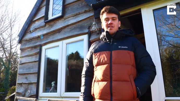 Un adolescente construye su propia casa de madera en el jardín de la casa de sus padres