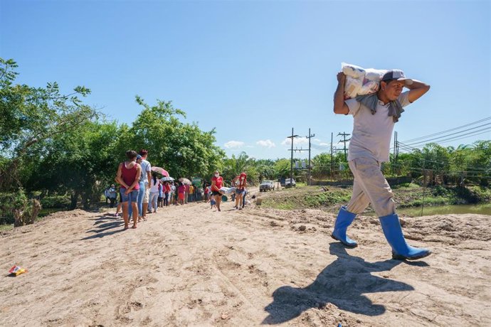Un hombre carga cerca de Coloma en Honduras con ayuda humanitaria.