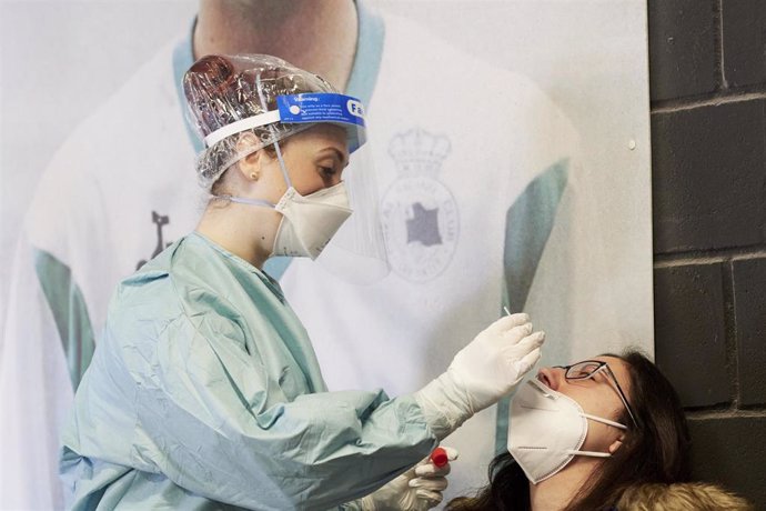 Una trabajadora sanitaria realiza un test de antígenos a una persona.