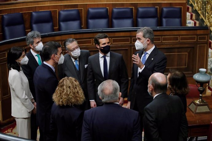 El rey Felipe VI (d) conversa con Miquel Roca (2d, de espaldas), uno de los "padres" de la Constitución; el presidente del Gobierno, Pedro Sánchez (3i); la presidenta del Congreso, Meritxell Batet (4d, de espaldas); el presidente del Tribunal Constituci