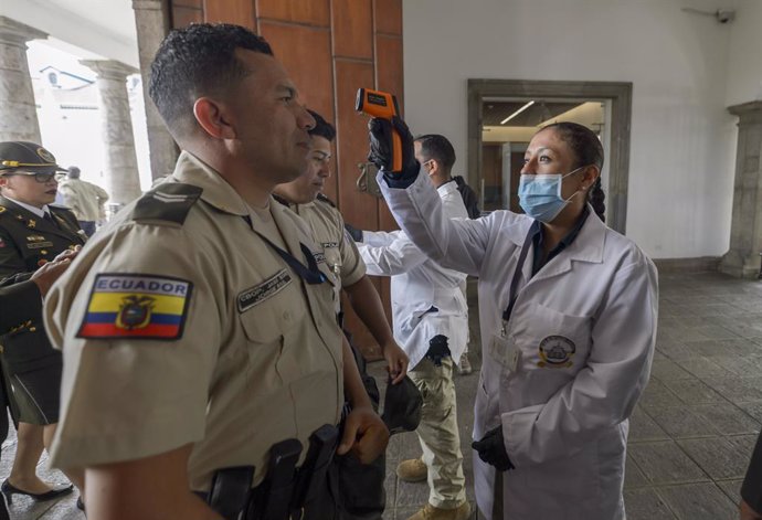 Archivo - Personal médico comprueba la temperatura de varios agentes de la Policía de Ecuador, en medio de la crisis sanitaria de la COVID-19.