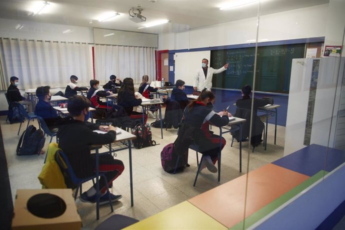 Archivo - Un profesor imparte clase a los alumnos del colegio Arcangel Rafael, en Aluche