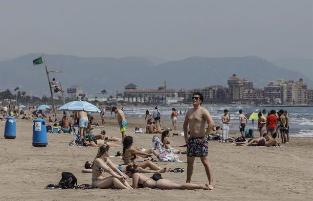 Archivo - Bañistas en la Playa de la Malvarrosa, con bandera verde durante el primer día de la Fase 2
