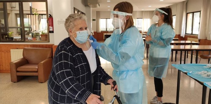 Una sanitaria administra una dosis de la vacuna contra la COVID-19 a una usuaria de un centro de día.