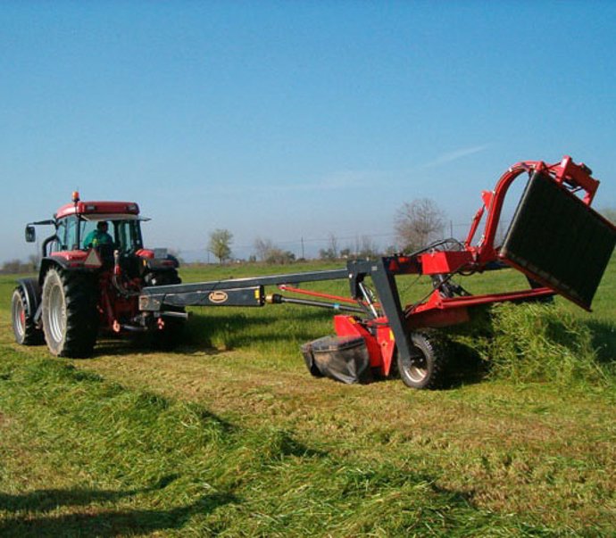 Archivo - Un tractor trabaja con maquinaria agrícola en el campo.