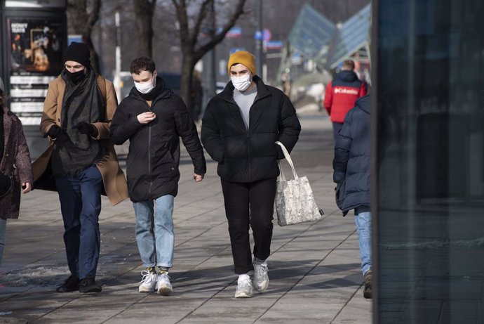 Tres personas caminan por la calle en Varsovia.