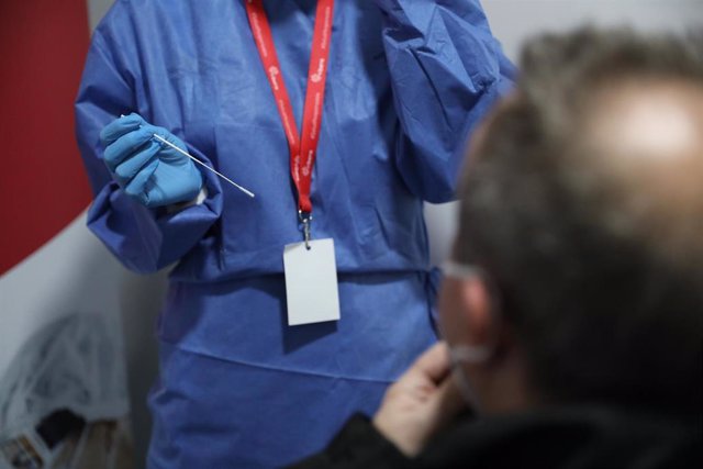 Un sanitario se dispone a realizar un test de antígenos a un trabajador en la estación de tren de Atocha, Madrid (España), a 22 de febrero de 2021. 