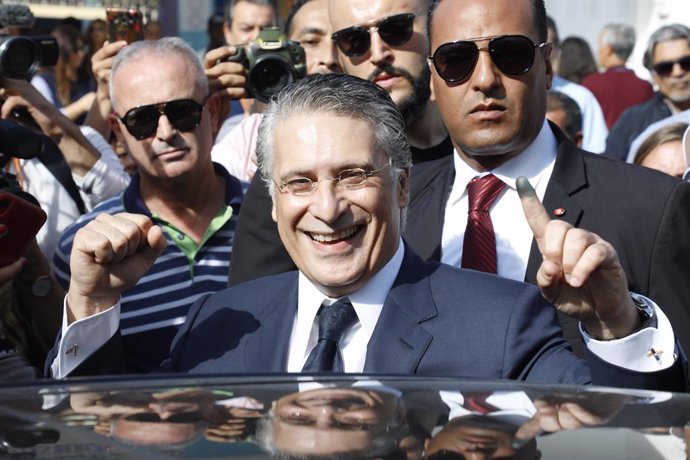 Archivo - 13 October 2019, Tunisia, Tunis: Tunisian presidential candidate Nabil Karoui greets supporters after casting his vote outside a polling station during the second round of the Tunisian presidential between presidential candidates Kais Saied an