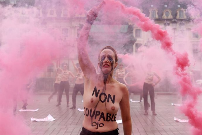 06 February 2021, France, Paris: A Femen activist, with "not guilty" written on her chest, lights a flare during a protest against sexism in the French judicial system at the Vendome square. Photo: Alain Jocard/AFP/dpa
