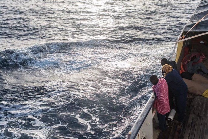 Refugiados y migrantes miran por la borda en el Mediterráneo desde la borda del Open Arms tras un rescate realizado la semana pasada.