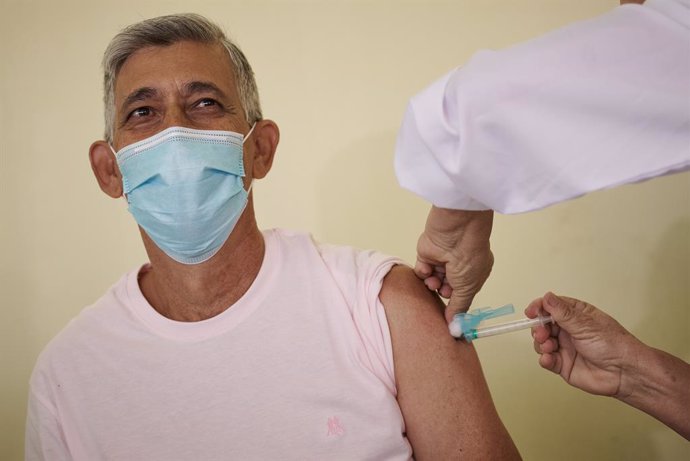Archivo - 21 January 2021, Brazil, Franca: Nursing technician Fernando Augusto Candido, 63, is the first in Franca to take the dose of the coronavirus (covid-19)vaccine that arrived yesterday with 3,300 doses for health professionals. Brazil is among t
