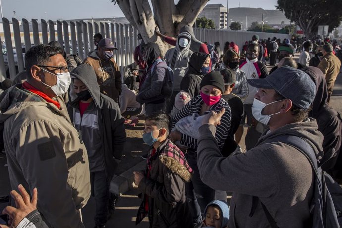 19 February 2021, Mexico, Tijuana: Migrants wait at the El Chaparral border crossing between Mexico and the US. Starting from today, the new US administration under US President Joe Biden will gradually allow the entry and stay of the last 25000 asylum 