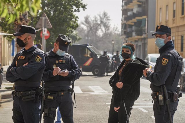 Varios agentes de Policía Nacional y una joven en la concentración organizada en las inmediaciones de  la Comisaría de Policía de Ruzafa
