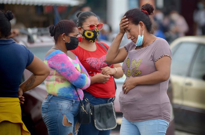 23 February 2021, Ecuador, Guayaquil: Relatives of prison inmates wait for information from the police after a mutiny in the regional prison No. 8. At least 50 people have been killed in several prison mutinies in Ecuador, according to police on Tuesday