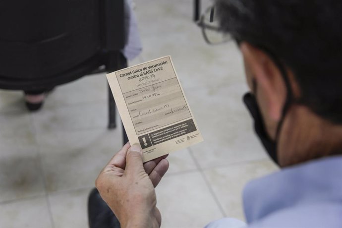 18 February 2021, Argentina, Tucuman: A man looks at his vaccination card at a vaccination centre at the launch of a Covid-19 vaccination campaign for people over 70. Photo: Adrian Lugones/telam/dpa
