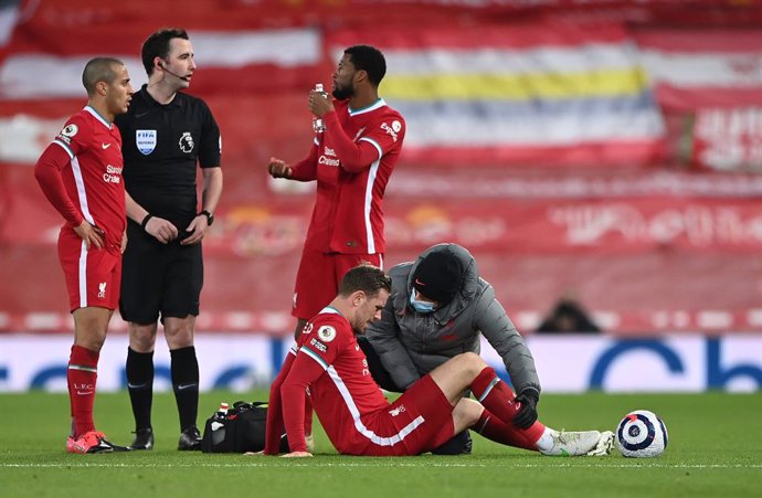 20 February 2021, United Kingdom, Liverpool: Liverpool's Jordan Henderson is checked by medical staff after picking up an injury during the English Premier League soccer match between Liverpool and Everton at the Anfield stadium. Photo: Laurence Griffit