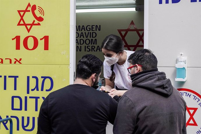 24 February 2021, Israel, Jerusalem: People wait outside a mobile clinic of Magen David Adom parked at the Mahane Yehuda Market to receive their dose of the Pfizer/BioNTech COVID-19 vaccine. Photo: Nir Alon/ZUMA Wire/dpa
