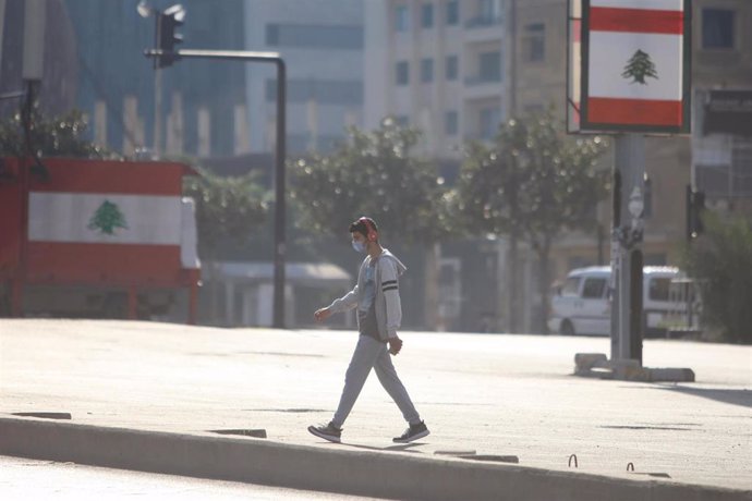 Archivo - Un joven con mascarilla en una calle de Beirut