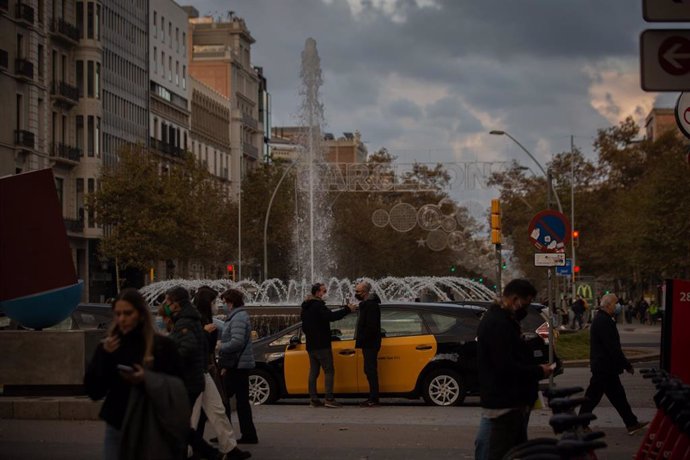 Archivo - Personas alrededor de un taxi, en Barcelona, Catalunya (España), a 25 de noviembre de 2020.