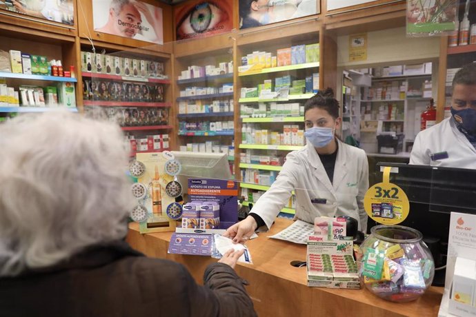 Una farmacéutica atiende a una señora