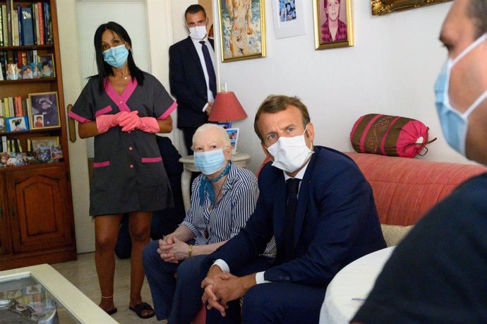 Archivo - 04 August 2020, France, Toulon: French President Emmanuel Macron (2nd R) visits 80-year-old Gisele Charles (3rd R) who lives alone in Toulon, as part of his meetings with home carers. Photo: Christophe Simon/AFP/dpa